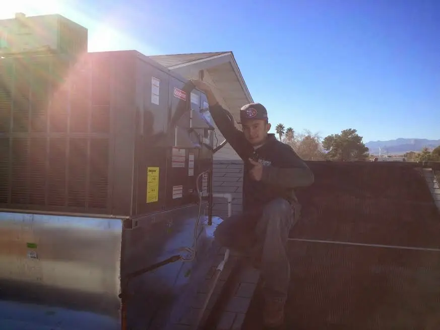 HVAC technician performing AC Tune-Up on a rooftop unit in North Londonderry